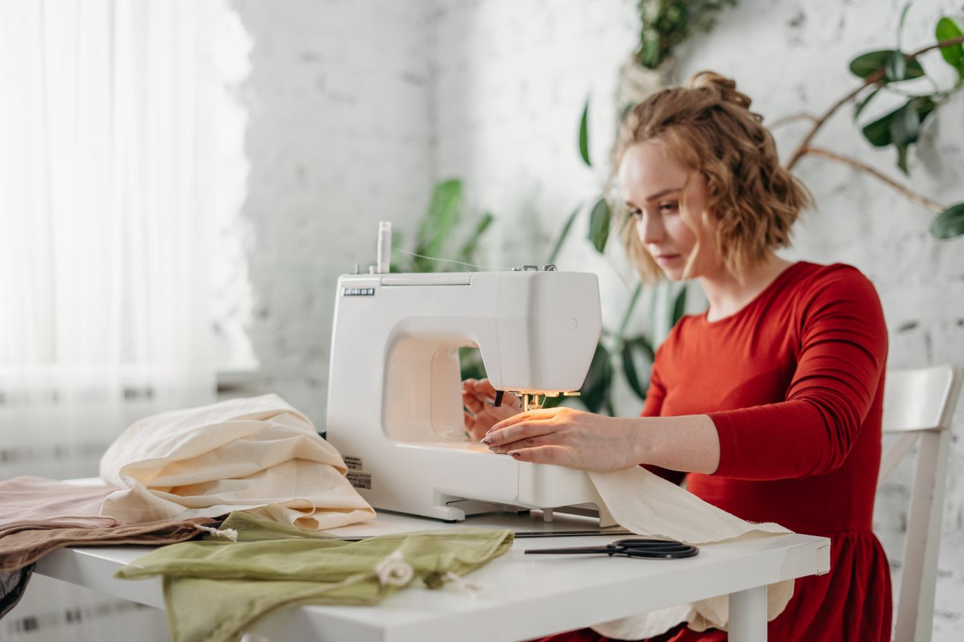 A sewist guiding plain fabric under a domestic sewing machine